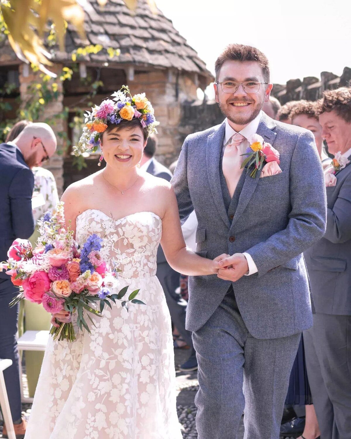bride and groom with colourful bouquet and flower crown