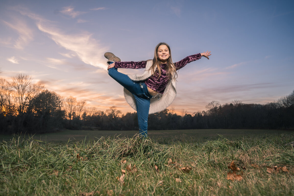 Young girl doing yoga at sunset in a field near Boston,  MA