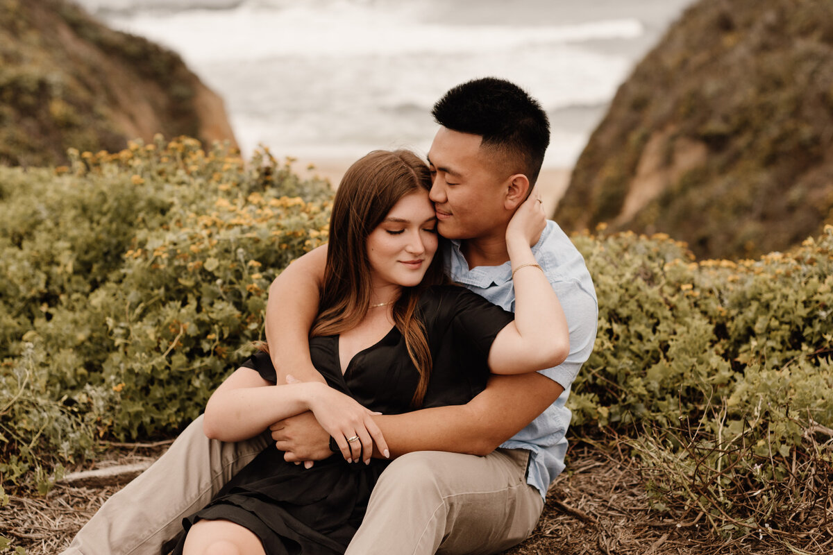 couple sitting on coast in half moon bay