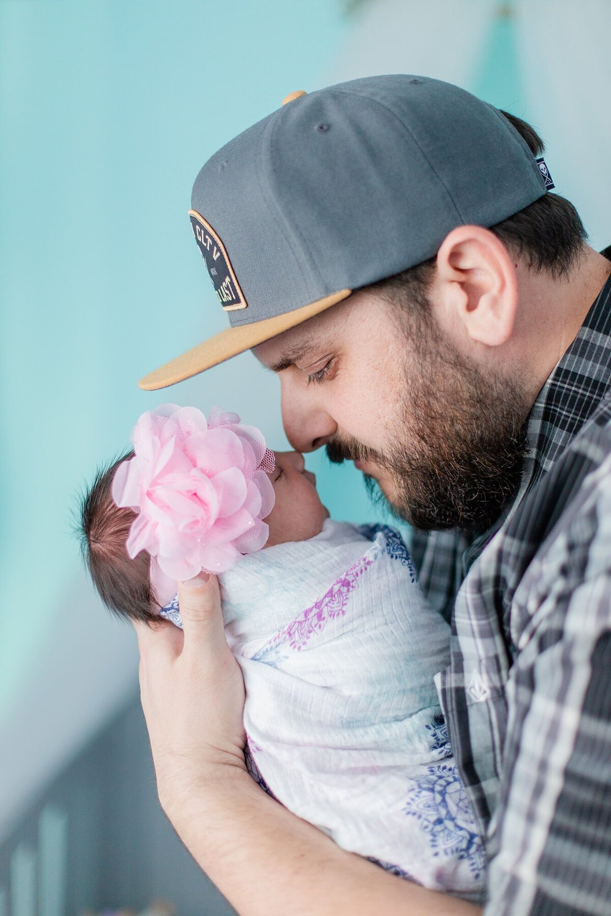 dad nuzzles newborn baby girl