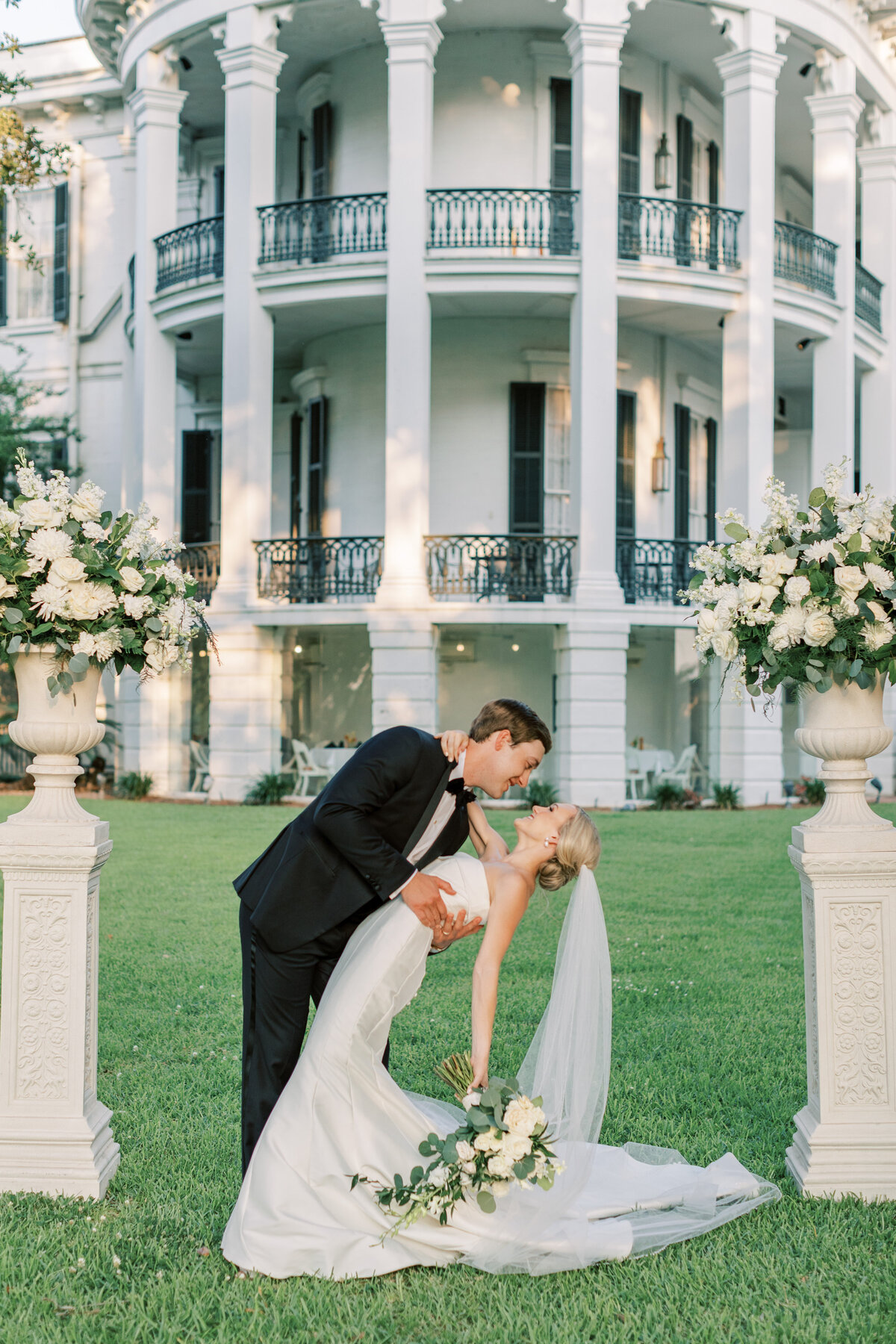 A husband dips the wife backward in front of Nottoway Plantation.
