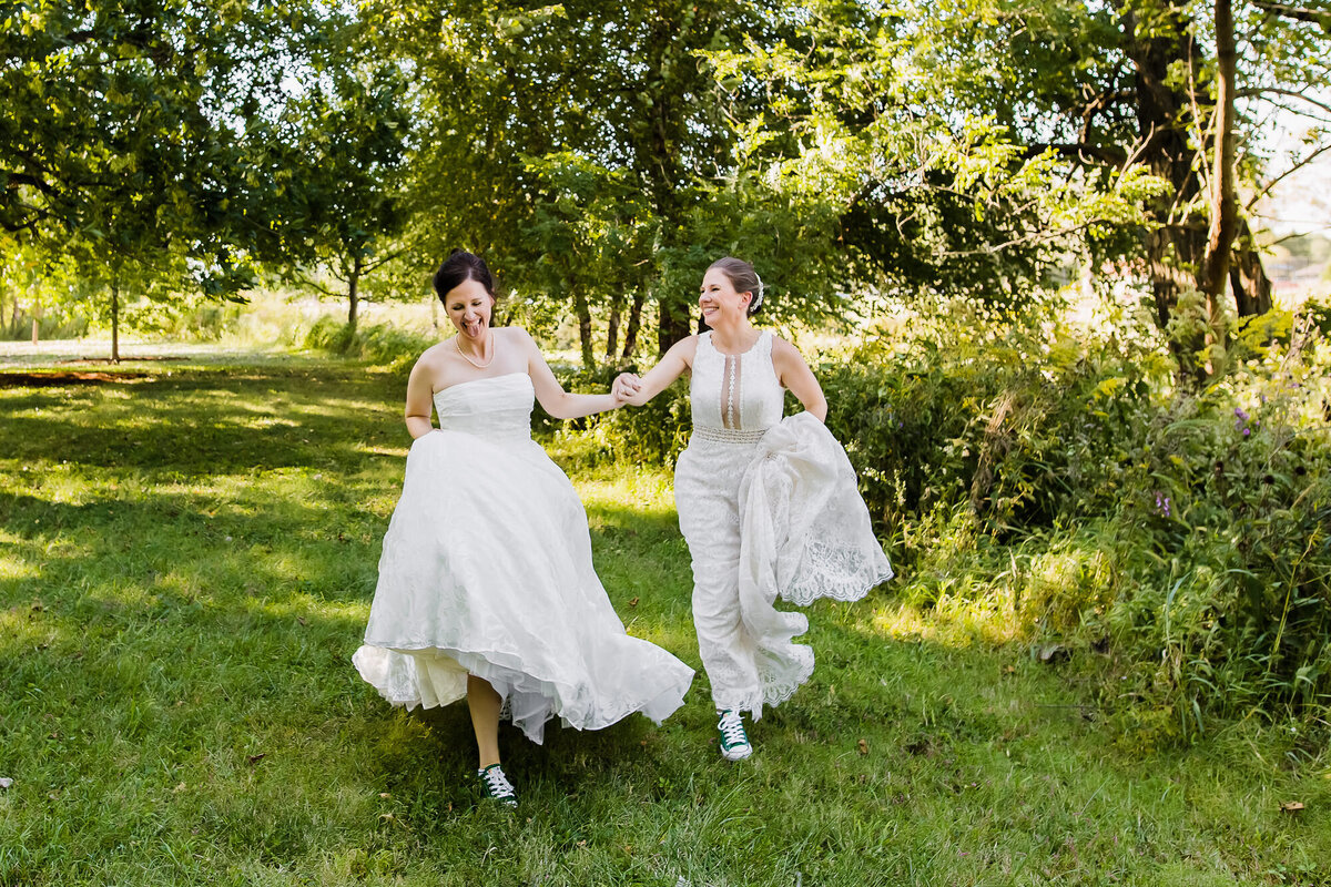 Brides running together in their dresses in Forest Park
