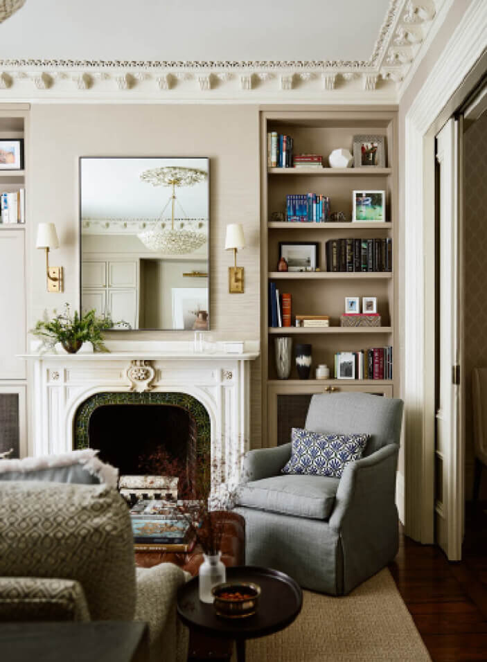 Classic Interior Design at a Boston brownstone renovation features an original marble fireplace, brass wall sconces, and traditional furniture in the South End.