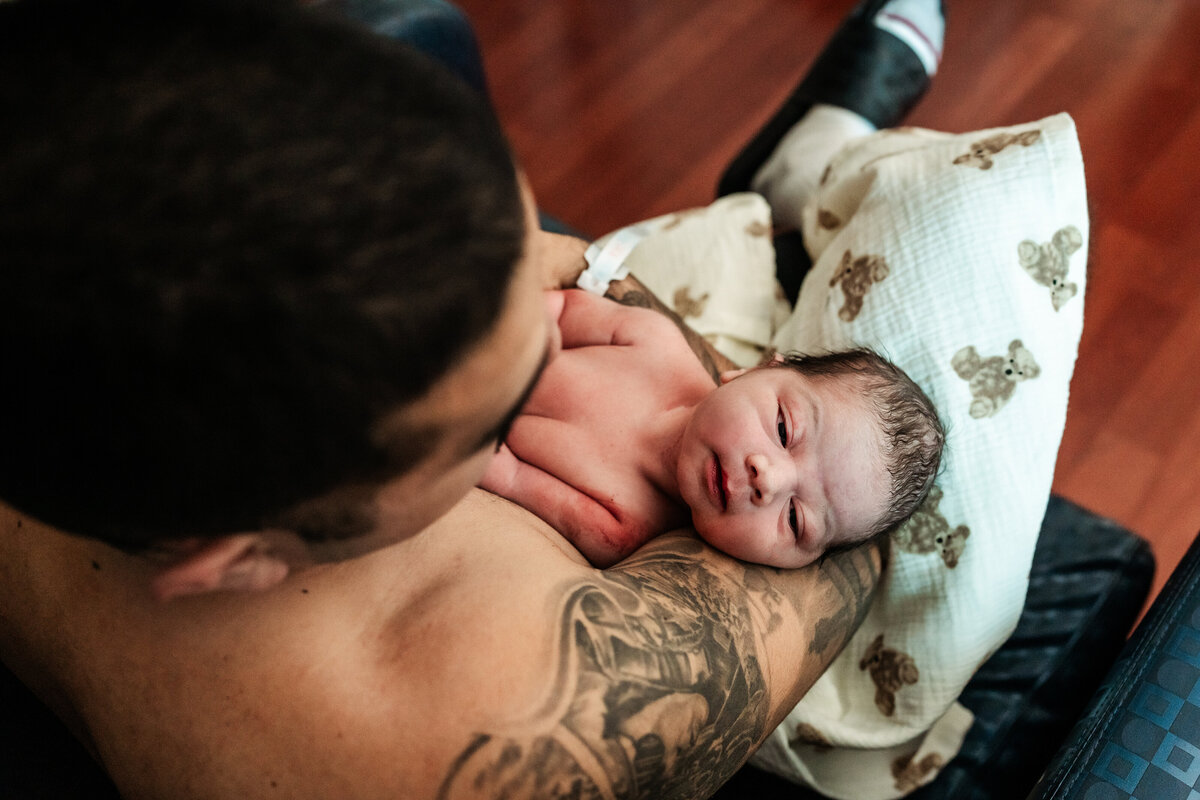 father-holding-his-son-in-his-arms-after-birth