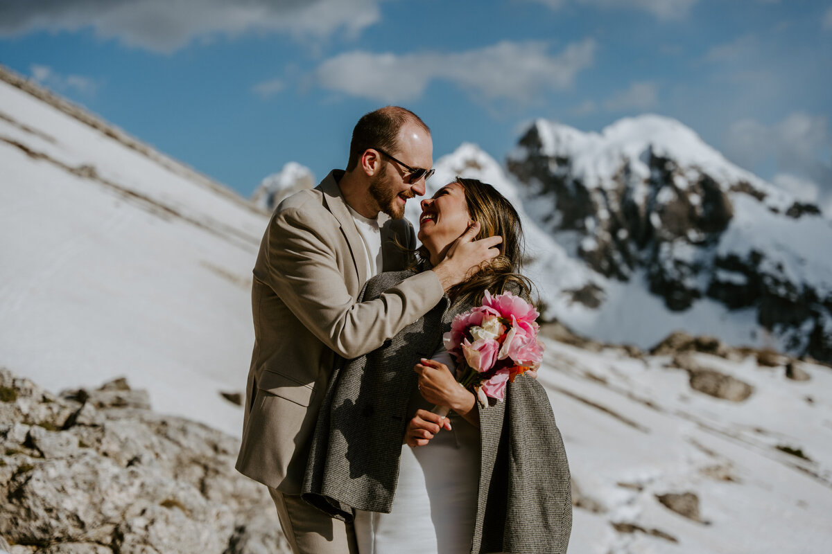 Couple walking rocky Dolomites trail with mountain views behind