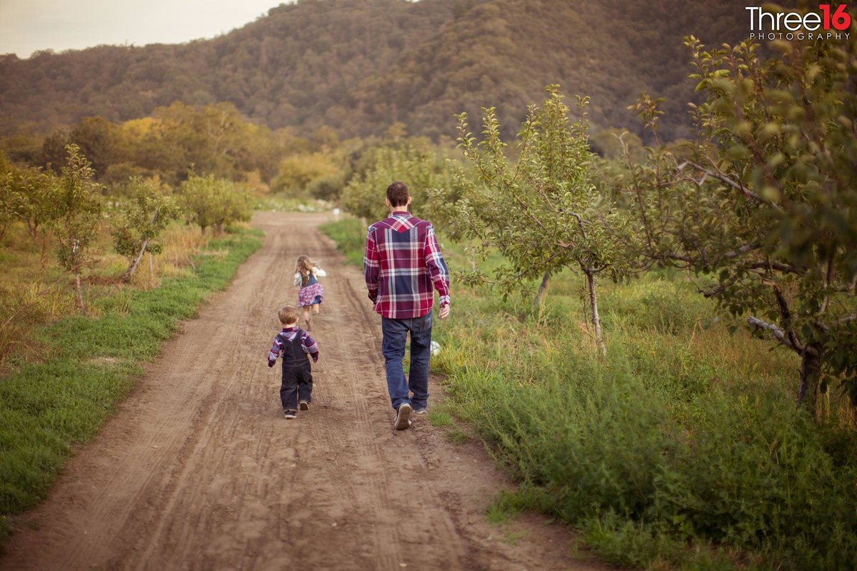 Father and his kids walk a trail at Riley's Farm