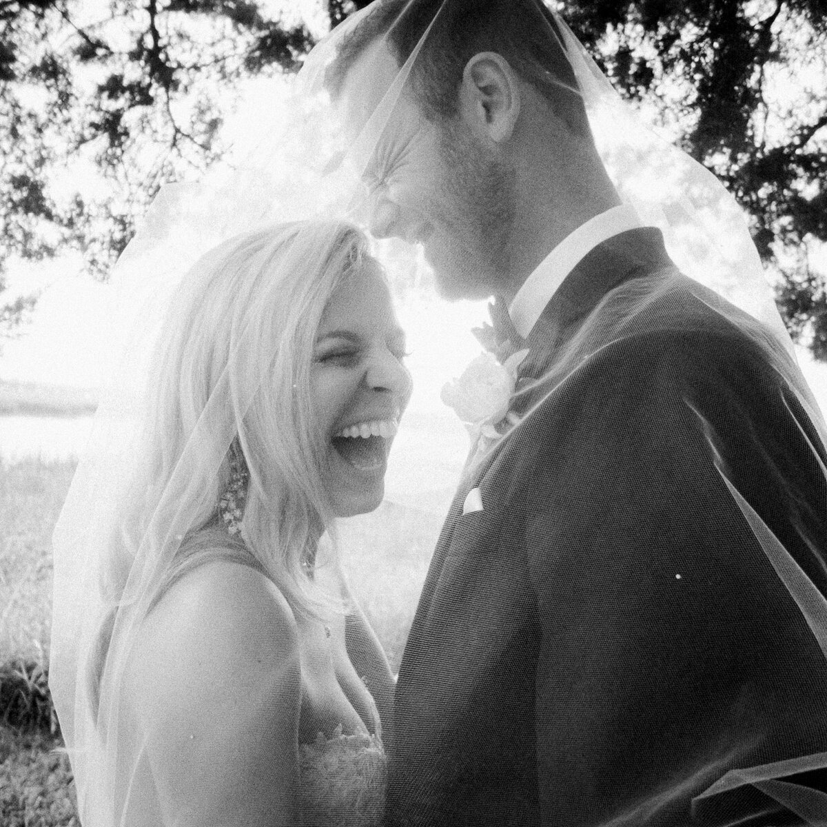 Bride and groom laughing with the sun setting behind them