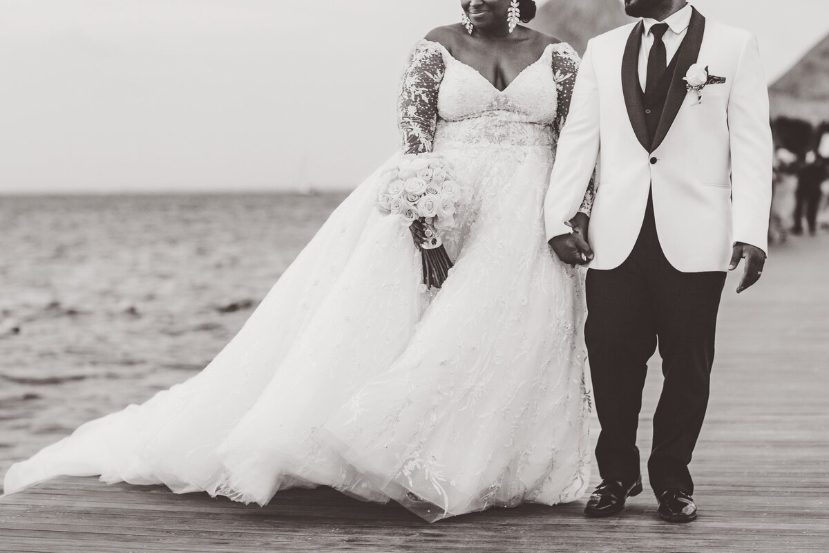 Close up of bride and groom holding hands and walking at wedding in Cancun