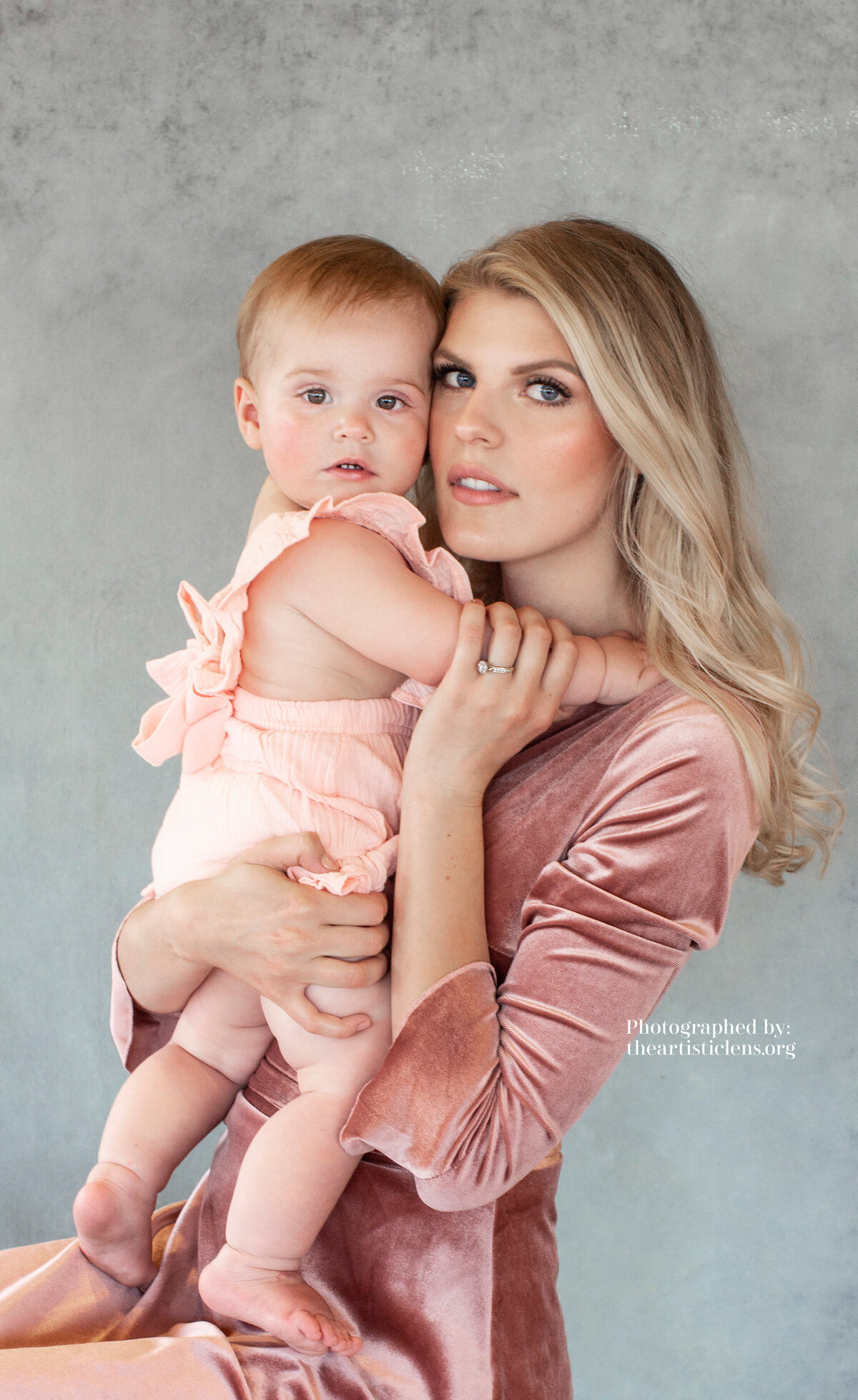 Mother and daughter portrait photographed on a hand painted canvas backdrop that is warm teal in color
