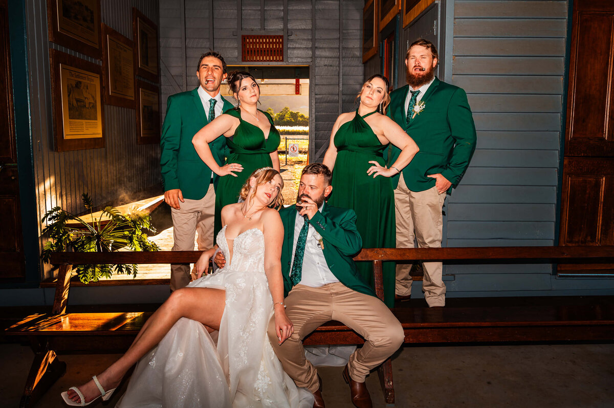 A joyful bride and groom pose with their wedding party, surrounded by smiles and the spirit of their special day. - photo by Jamie Simmons