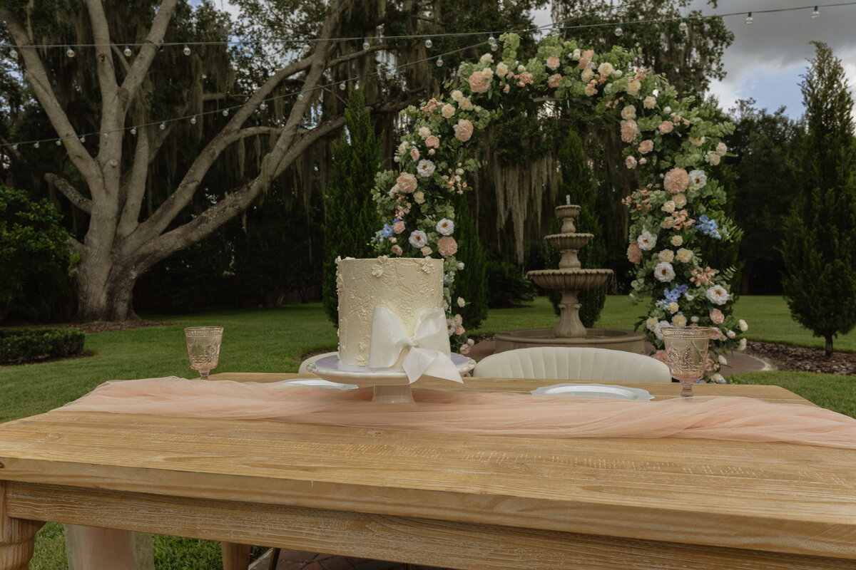 Intimate Florida wedding ceremony in the backyard of The Palm Mansion with soft florals and palm tree views
