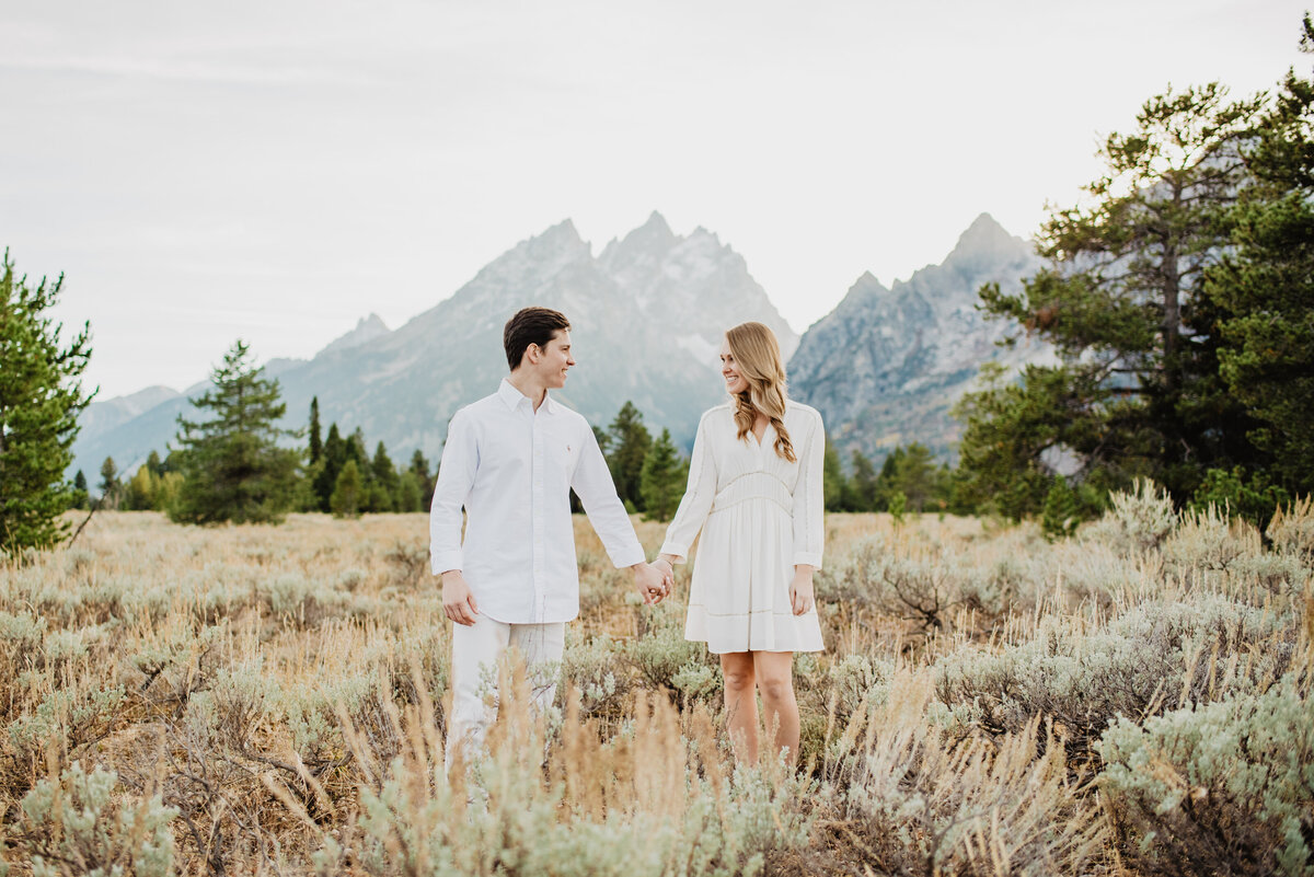 Photographers Jackson Hole capture fall engagements of man and woman holding hands