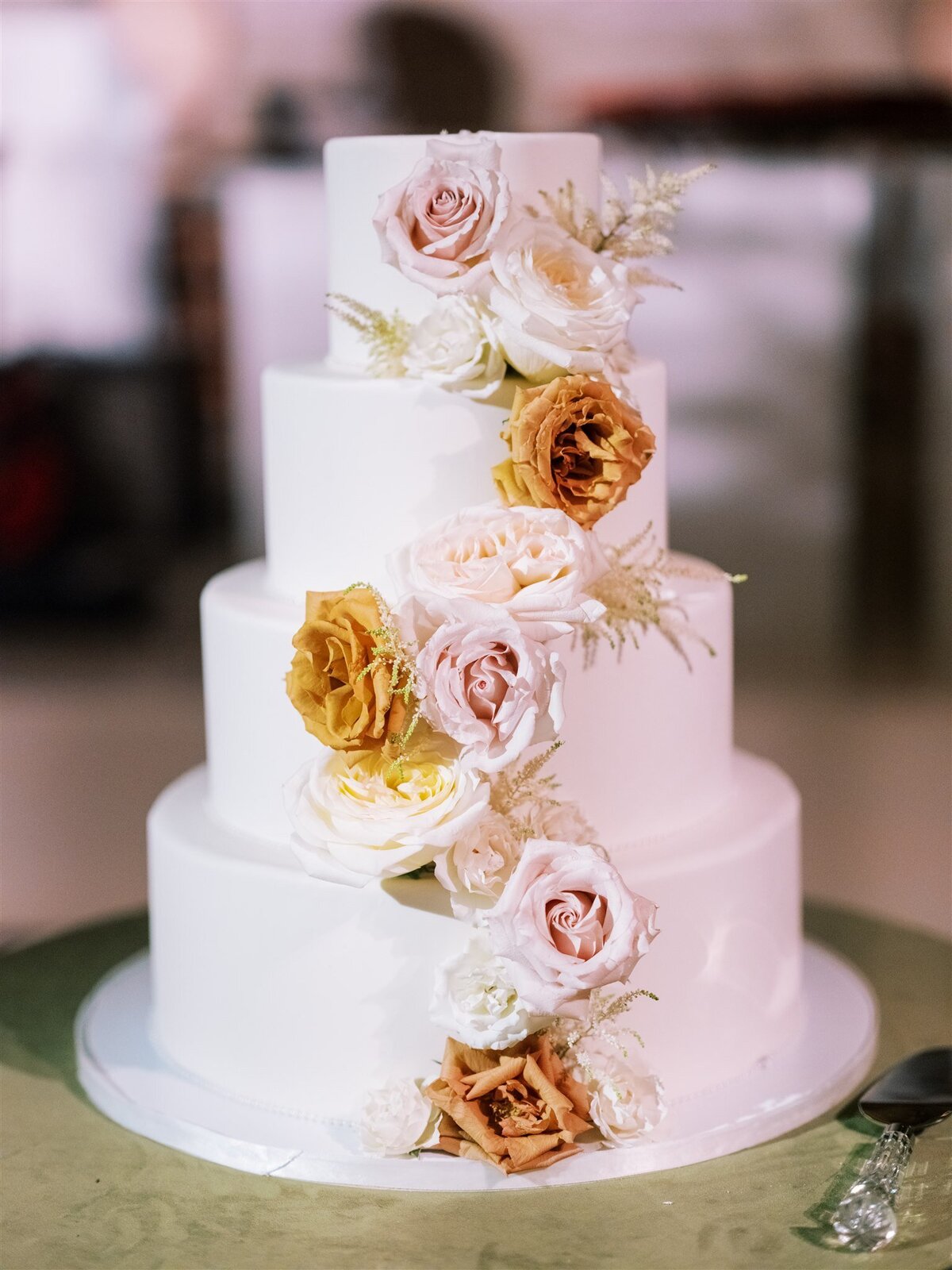 A close up of the wedding cake decorated with flowers. 