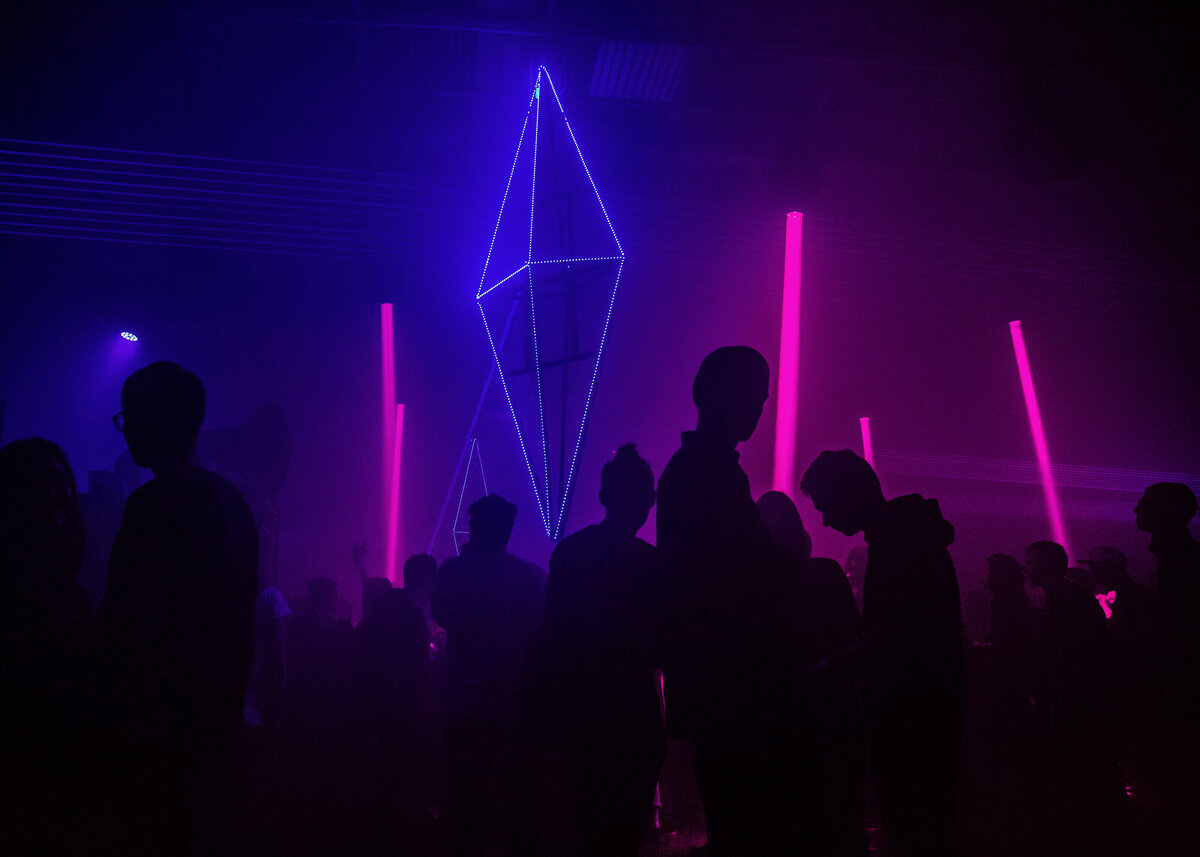 A nightclub party with a large blue neon diamond for a brand event
