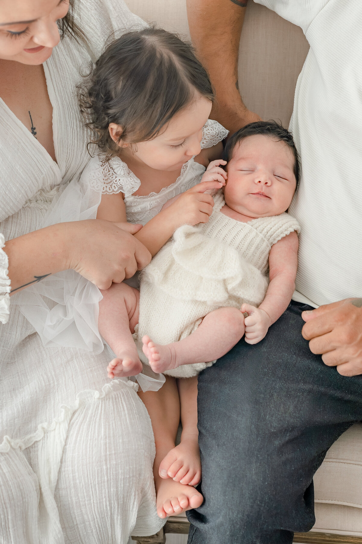 Sister holding baby during natural light Barrie newborn photography session 