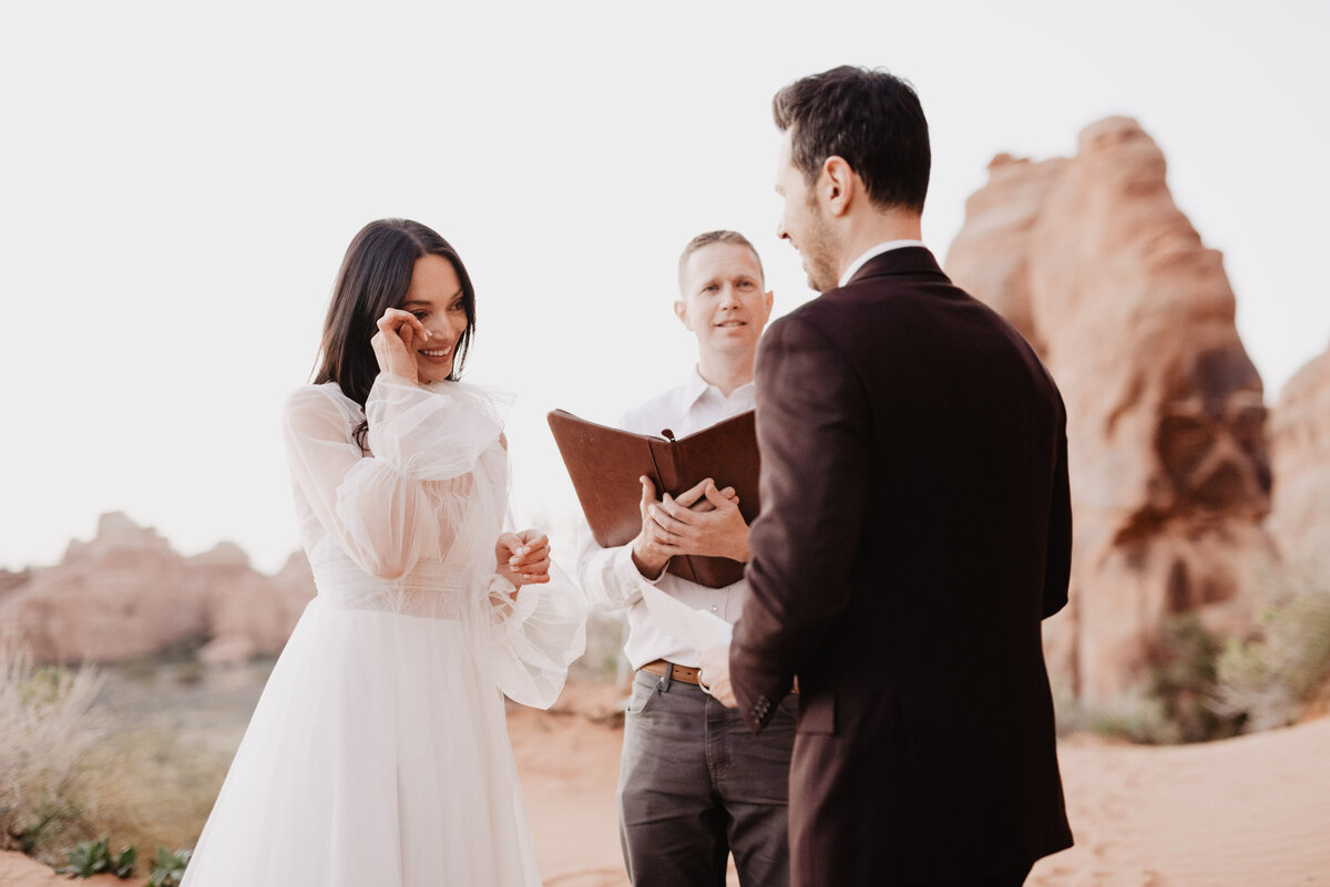 Utah elopement photographer captures bride wiping tears during intimate vows