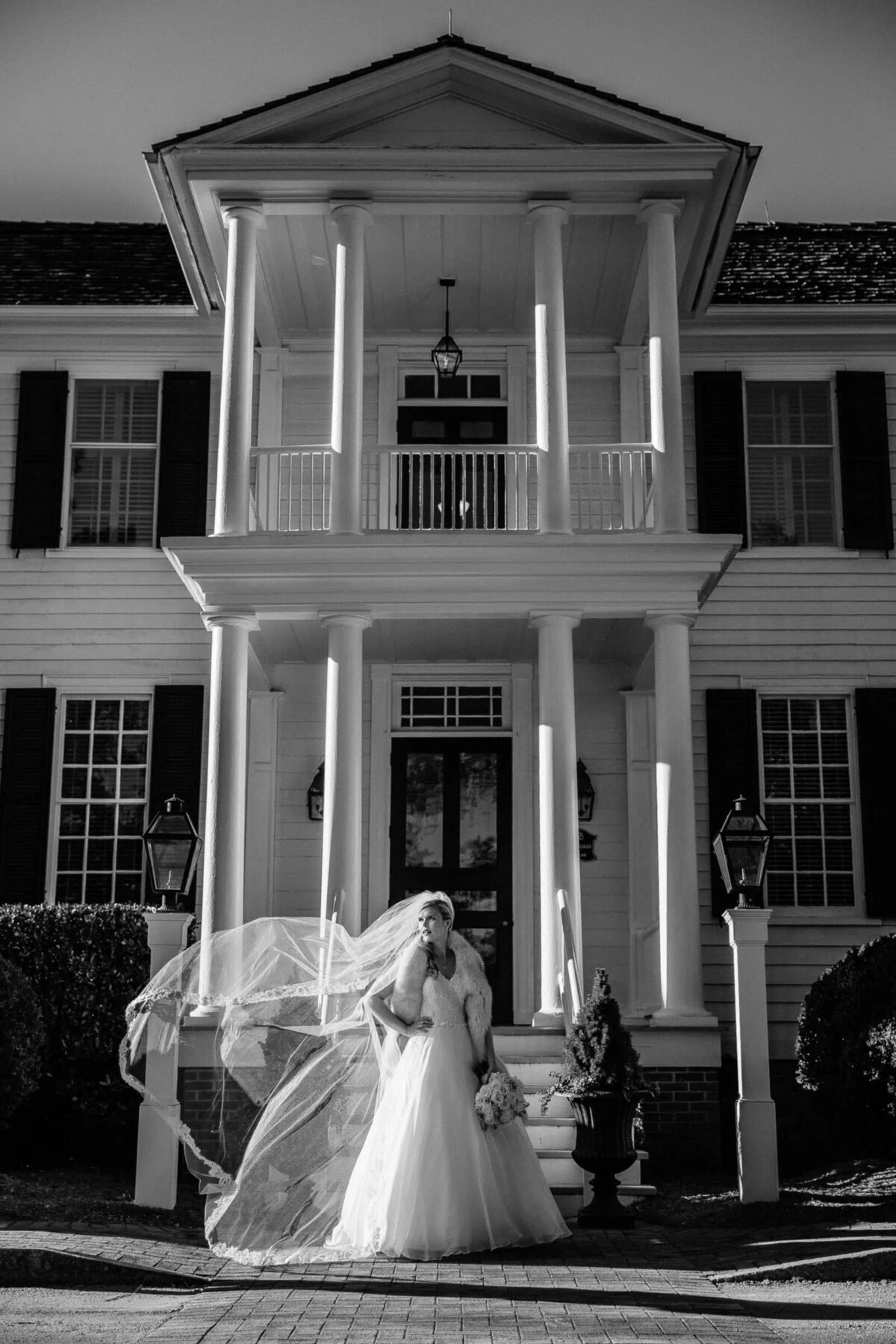 A bride standing in front of a large house