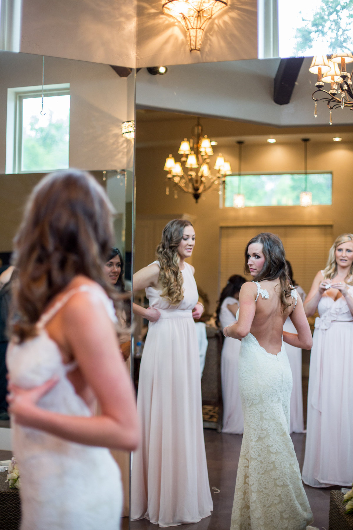 Bride looking in mirror at back of wedding dress as she gets ready for ceremony at Remi's Ridge at Hidden Falls venue