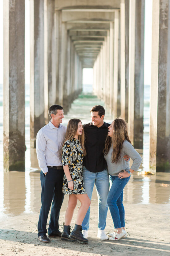 family-laughing-together-under-Scripps-Pier-San-Diego