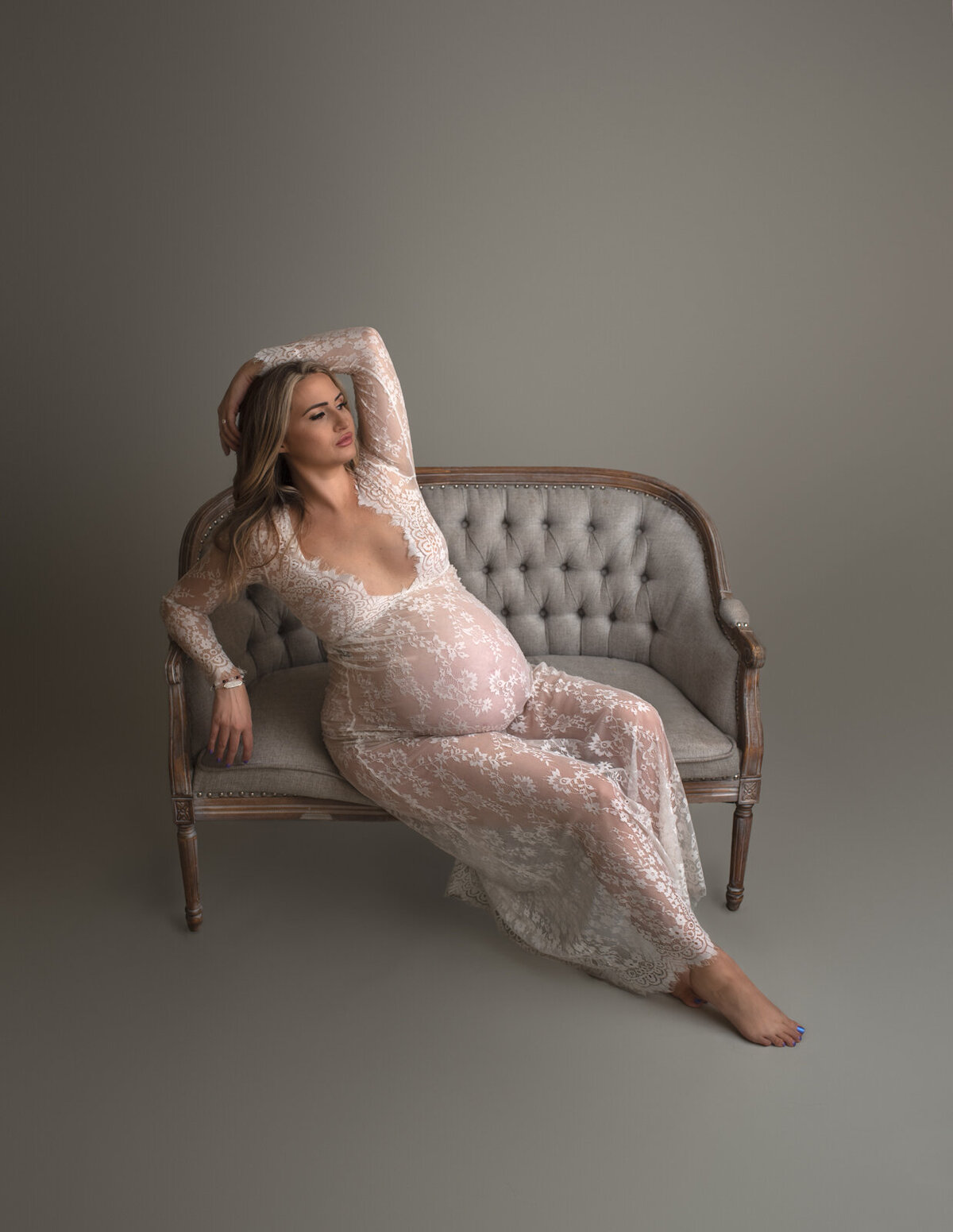 pregnant mom on couch in lace dress