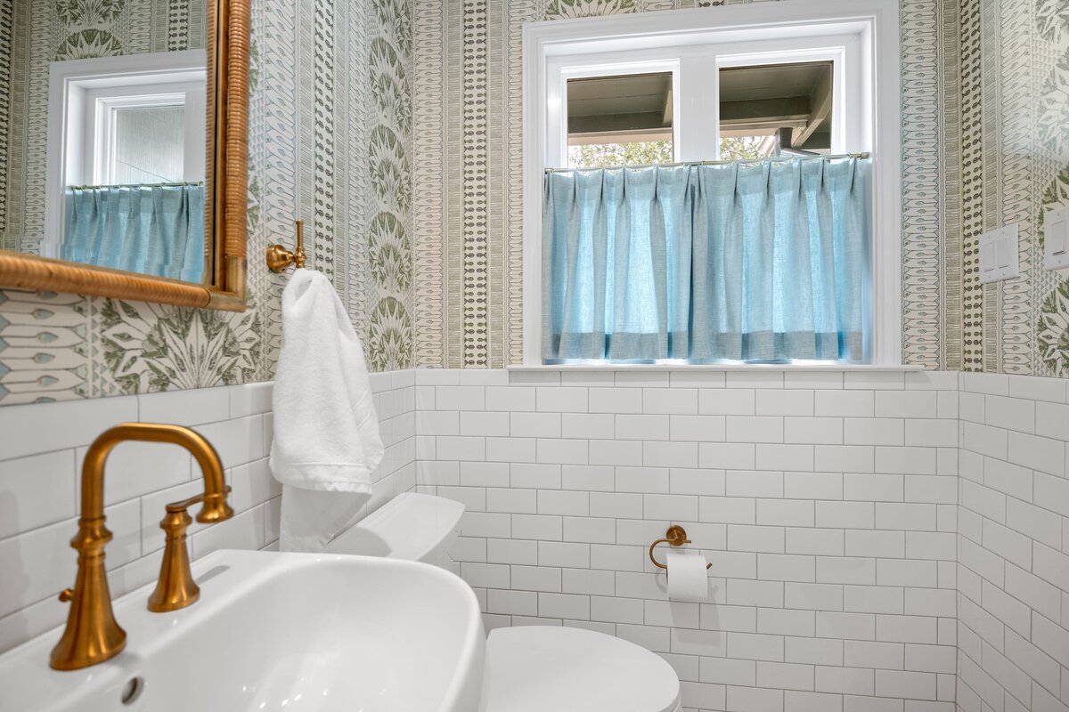 the keeping room interiors oakview half bath with blue curtains on window