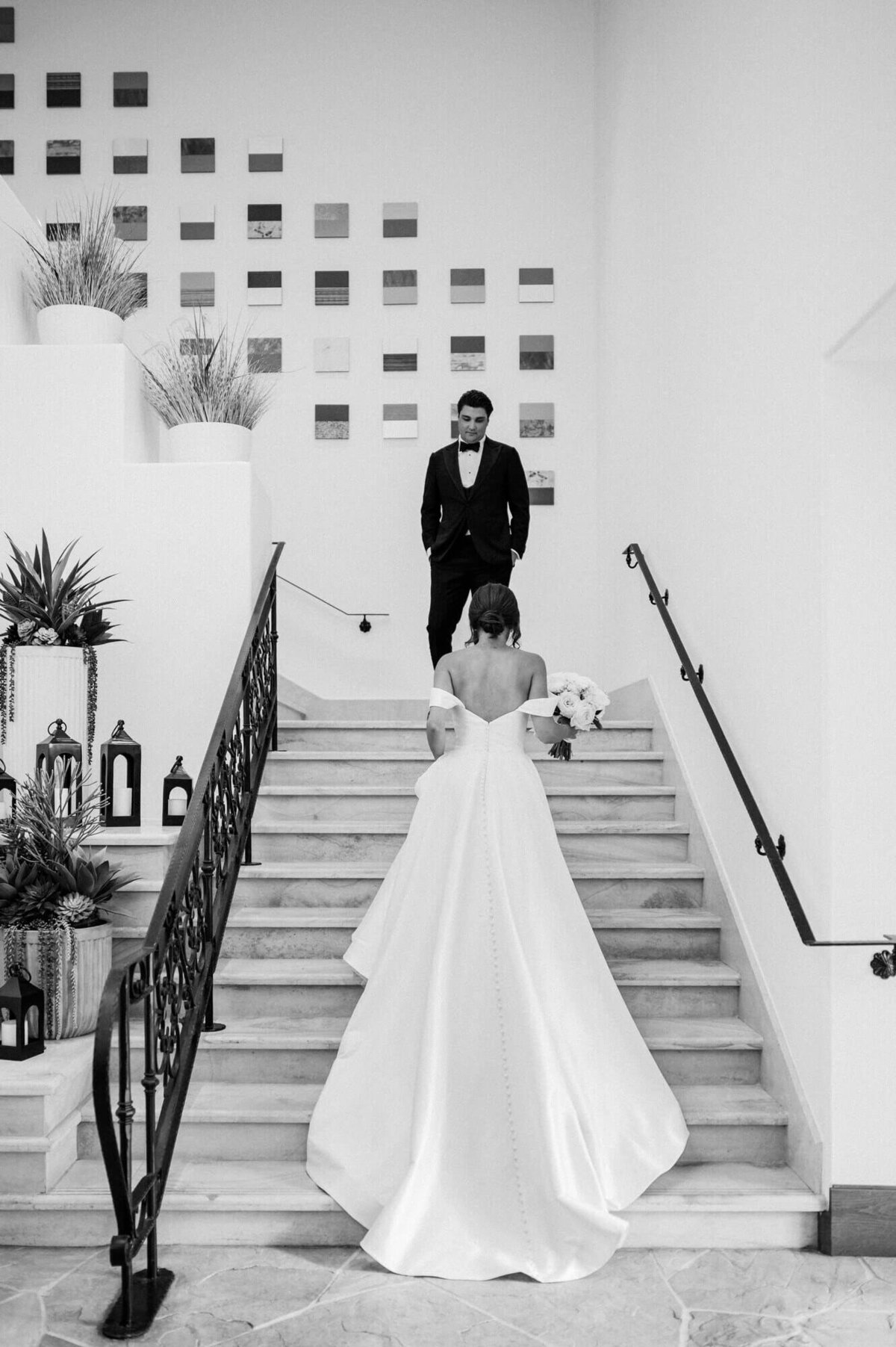 Bride walking up the marble staircase for her first look with the groom at Four Seasons Scottsdale, captured by Scottsdale wedding photographers.