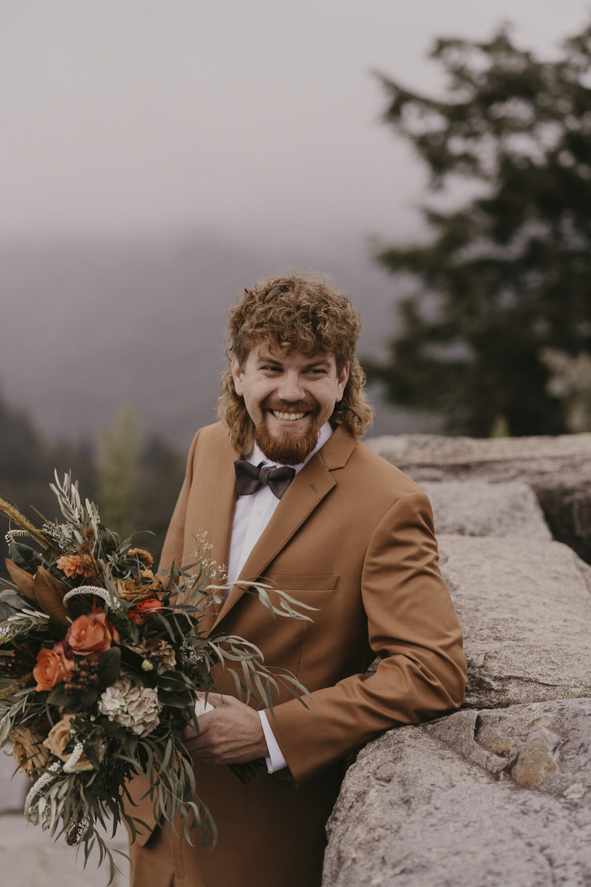 Groom in orange suit holding orange bouquet