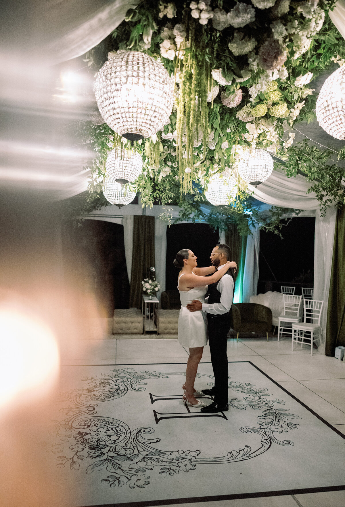 The newlyweds share a romantic private last dance beneath floral chandeliers inside the Castle Ladyhawke reception tent.