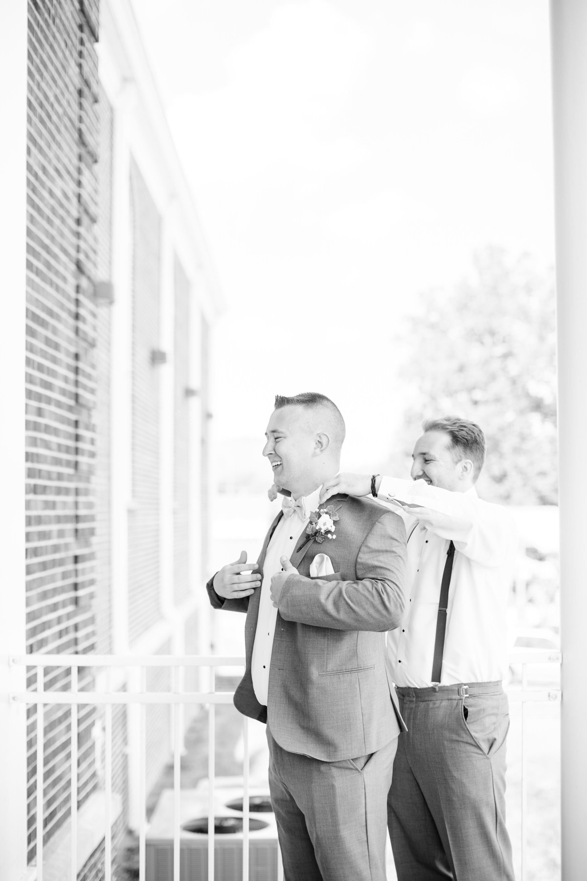 A groomsmen helps his friend get ready for his wedding day in Georgia, Elizabeth Hill Photography