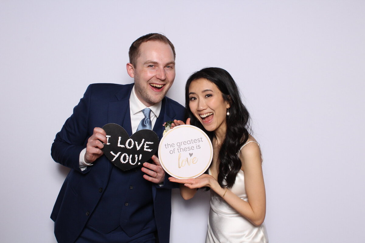 Couple using photo booth props at their wedding reception