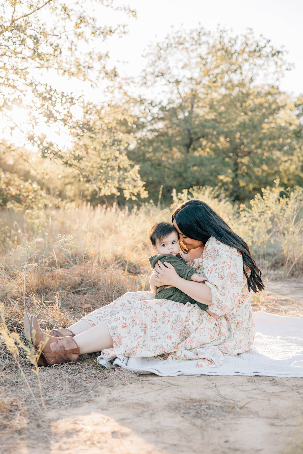 Outdoor fall family session with a motherhood image with her son in tall grass at sunset located in Flower Mound, TX