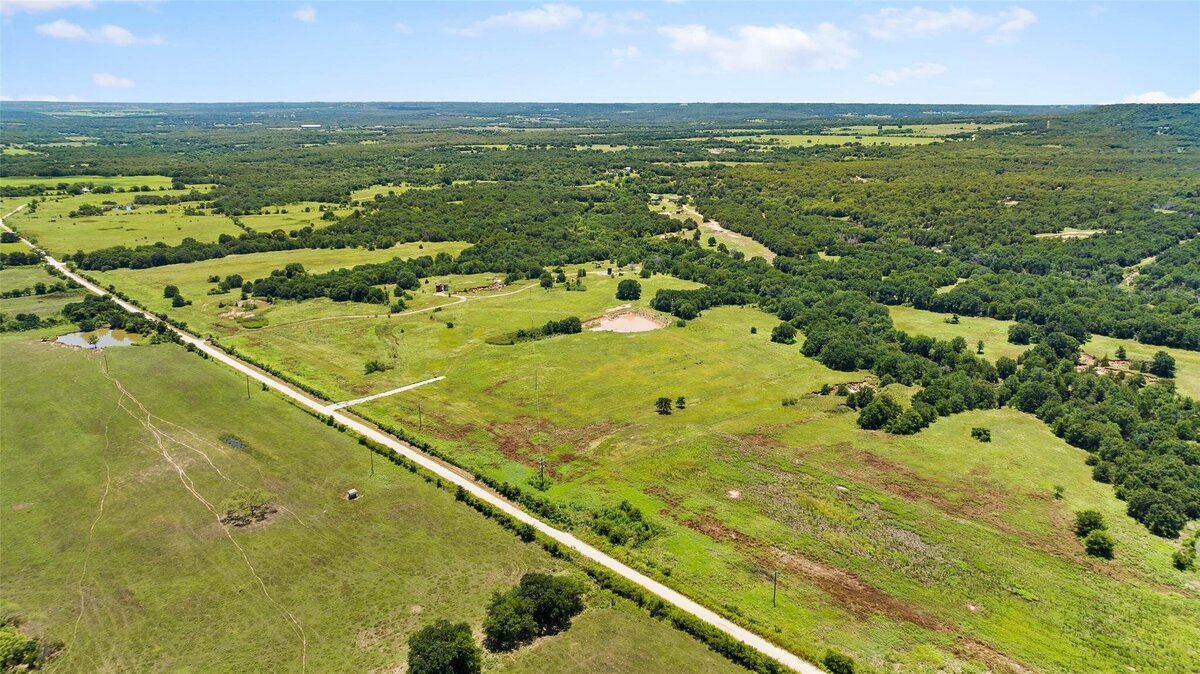 Aerial view of 55-acre property with mature post oaks in Saint Jo, TX