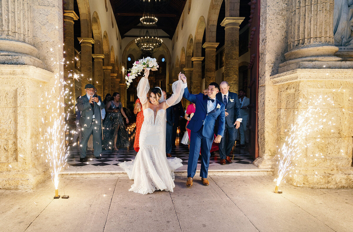 Victoria and Daniel make a grand wedding exit with sparklers illuminating their path in Cartagena Colombia.