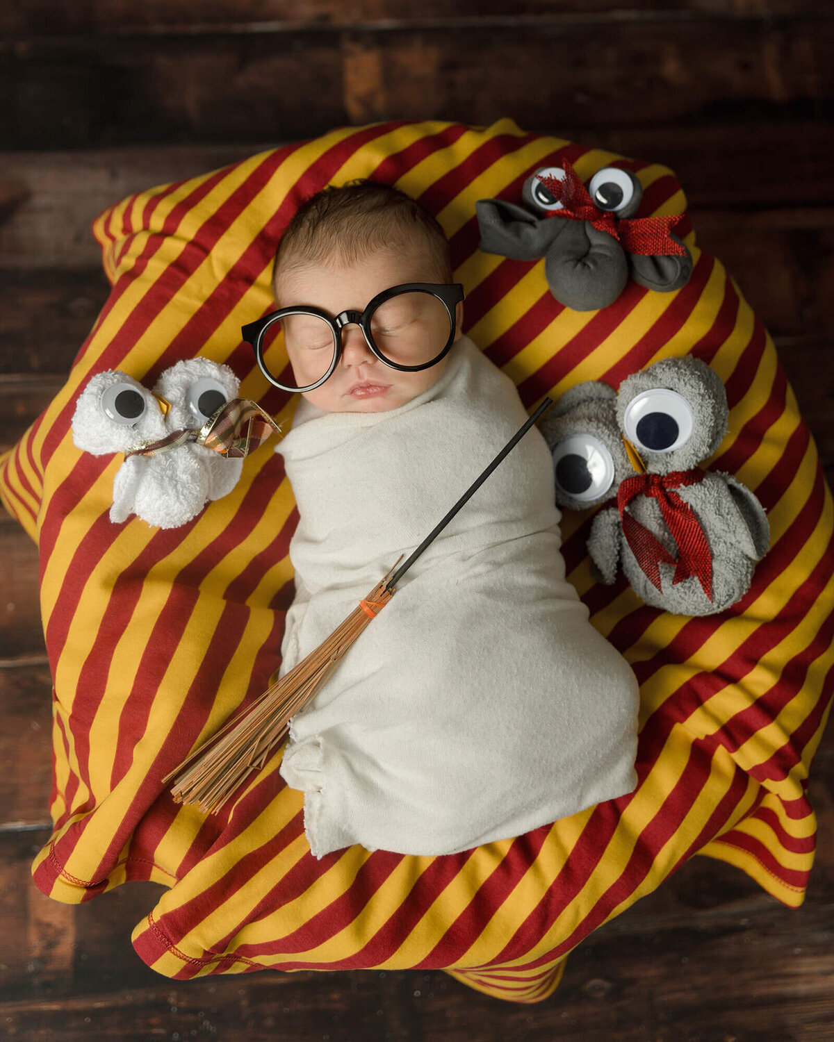 Newborn boy wearing glasses in a Harry Potter themed photo.