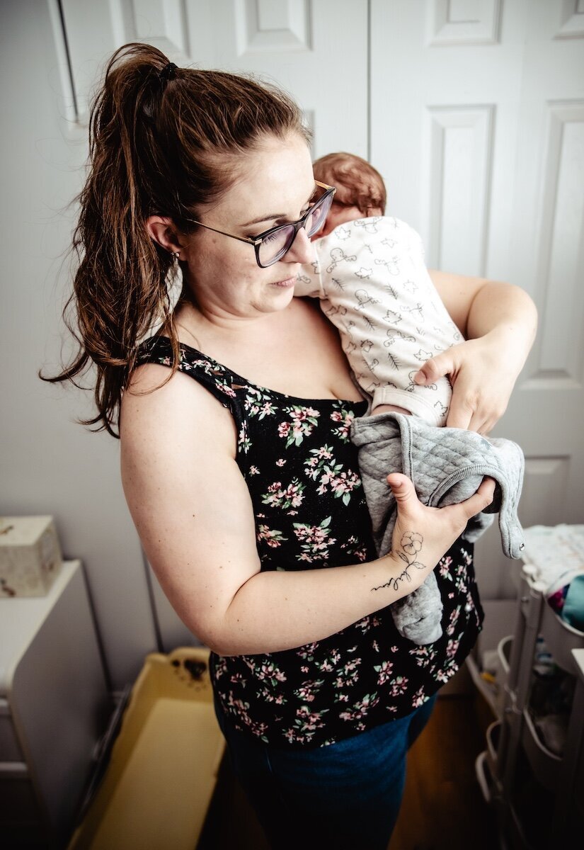 a new mom gets her two day old baby girl dressed in her Edmonton nursery