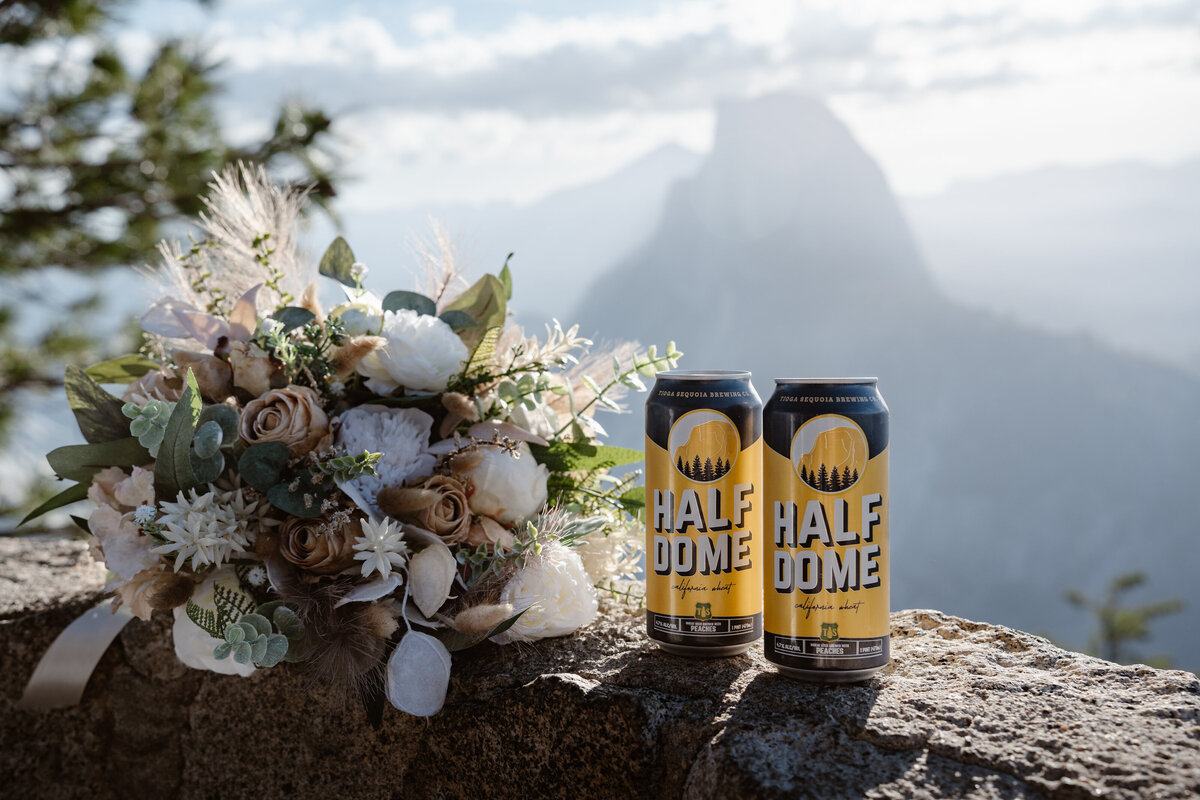 Two beer cans next to a bouquet of flowers