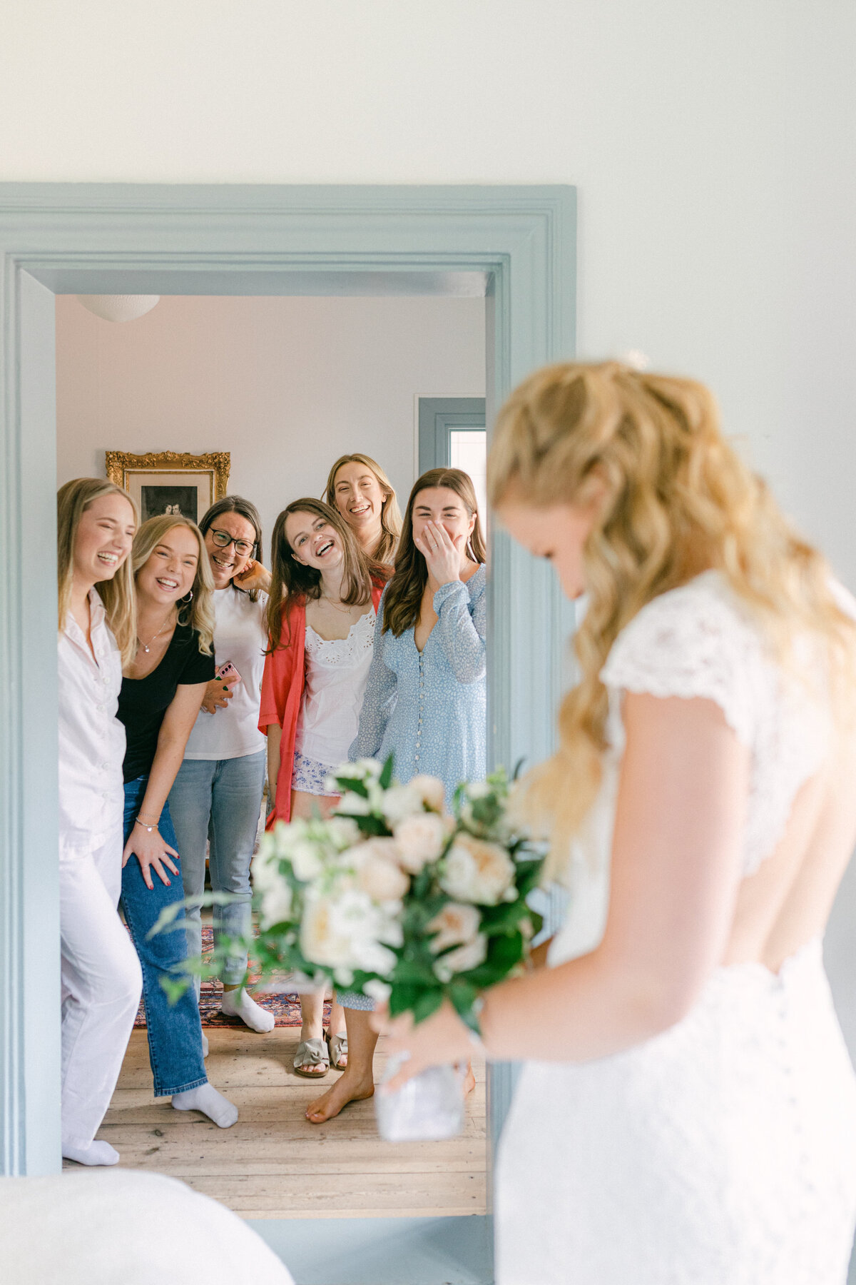 Glada brudtärnor tittar på blivande brud i bröllopssviten på Schenströmska