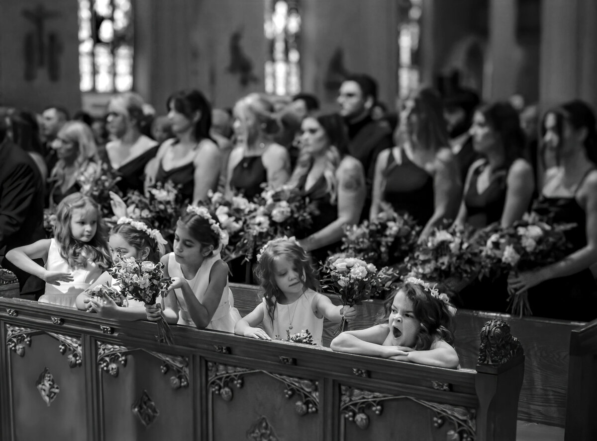 Five flower girls occupy themselves during a ceremony with one yawning.