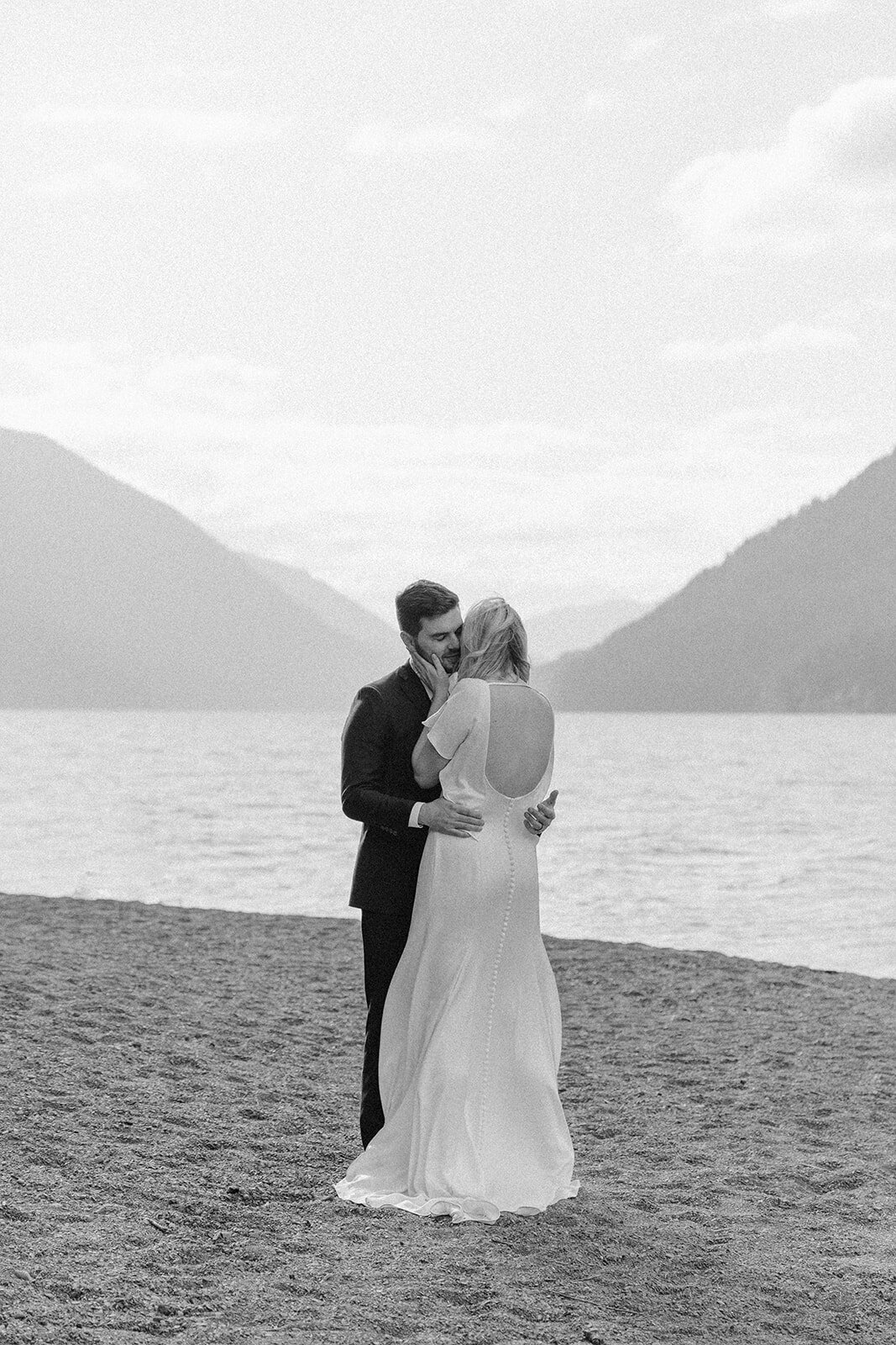 Black & white photo of bride & groom hugging on Lake Crescent during Olympic National Park adventure elopement!