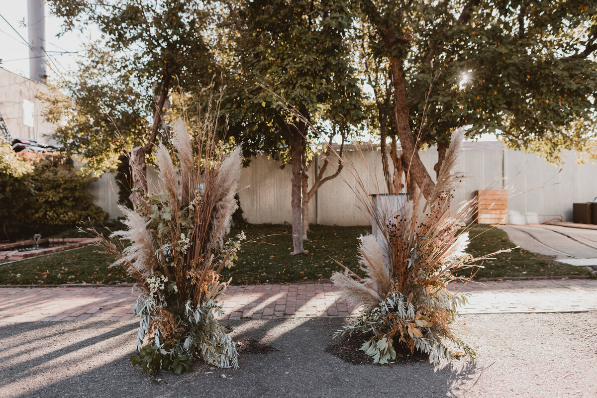 Boho orange, white, greenery, and pampas grass at the head of a wedding ceremony at Blanc Denver.