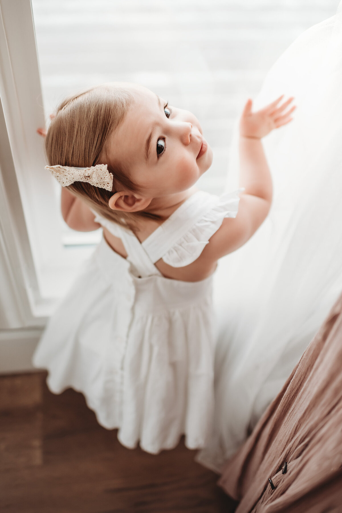 two year old looking out window in denver photographer studio