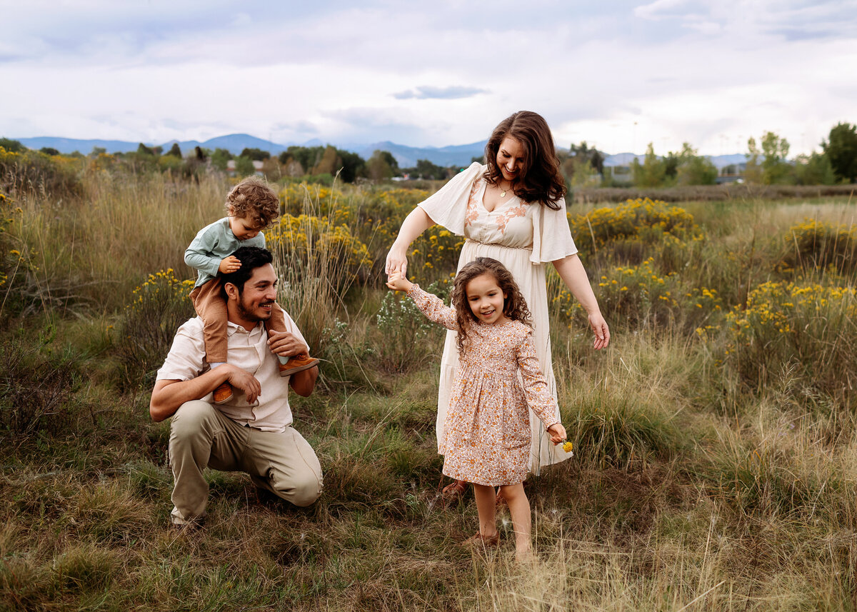 family playing in a field for their denver family photo session