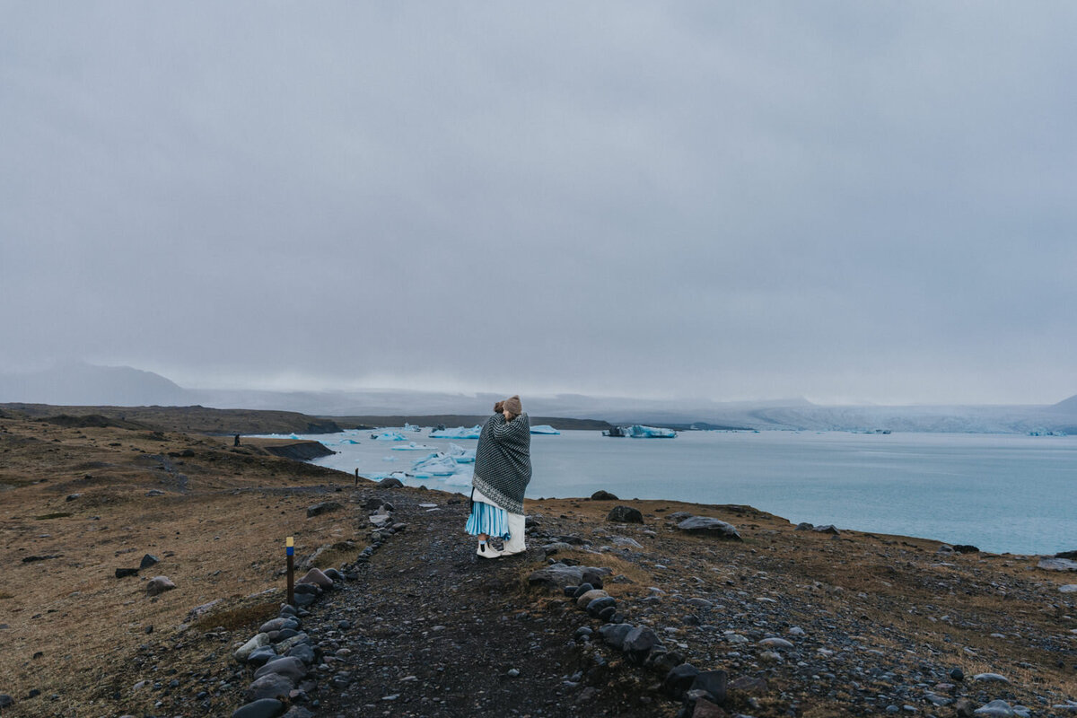 Newlyweds wrap a blanket around each other as they hug 
