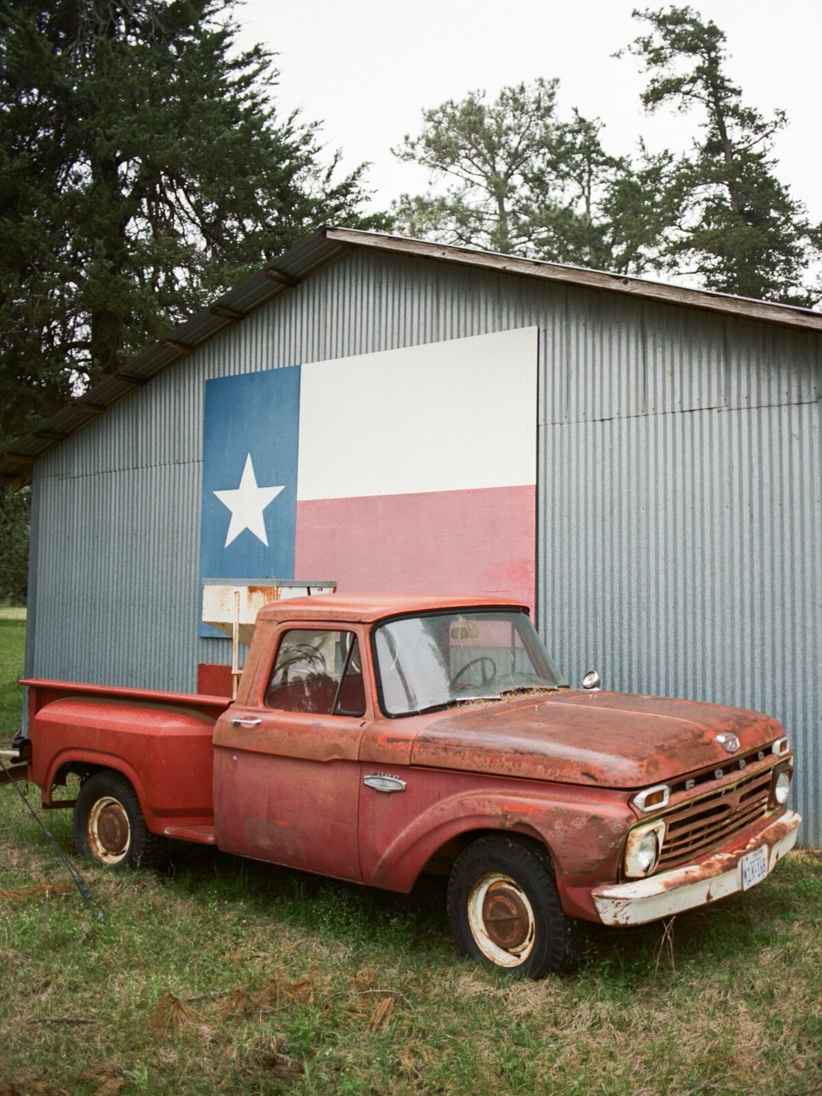 Red truck parked in front of a barn in Carmel, captured in a candid, documentary style by Kate Winters Photography.