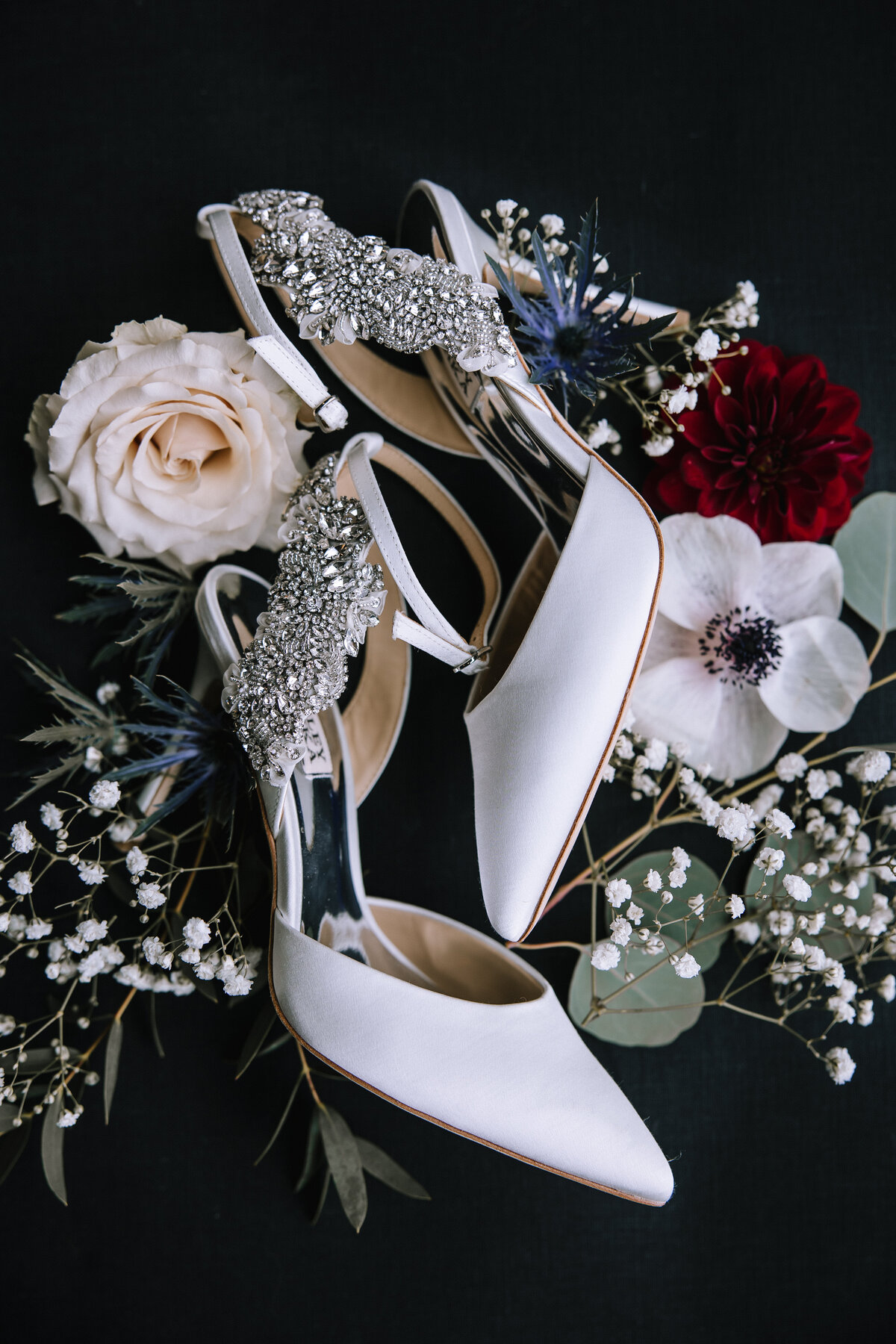 Wedding flatlay of bride shoes with flowers by Gidas Flowers.