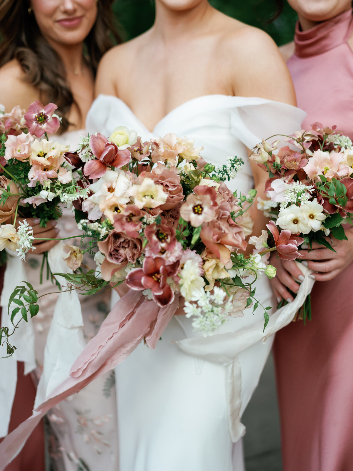 close up photo of bride and bridesmaid's bouquets of white, mauve and taupe florals.