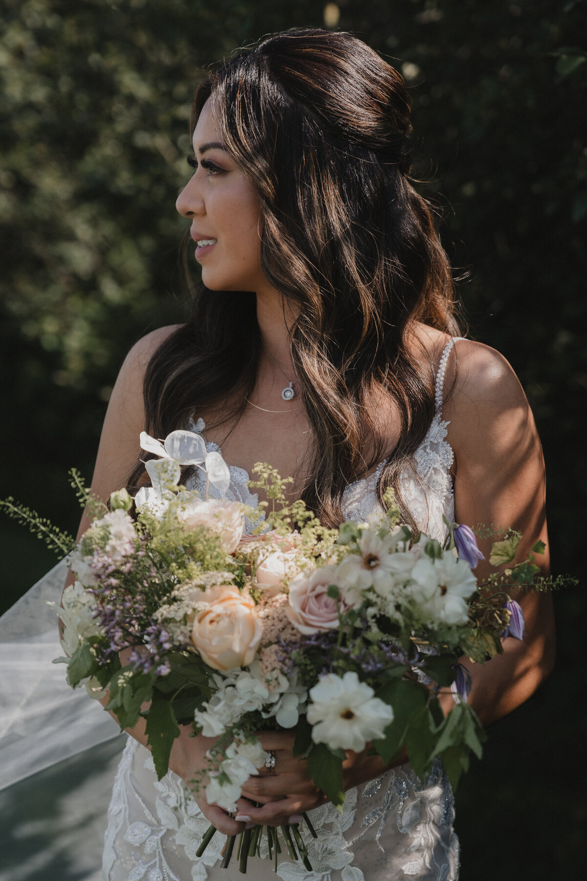 Portrait lumineux d’une mariée tenant un bouquet champêtre et romantique, capturé en pleine nature par Jeff Gagnon photographe.