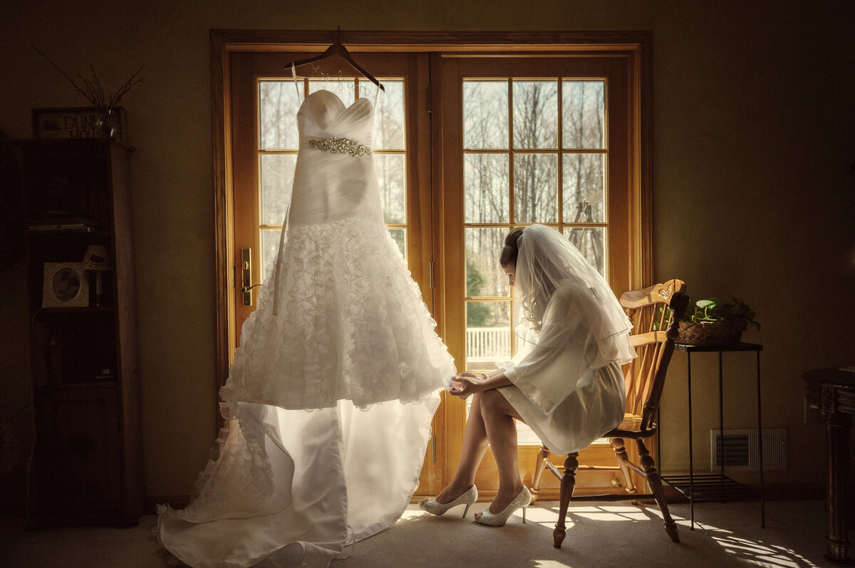 Bride looking at her wedding dress before her wedding.