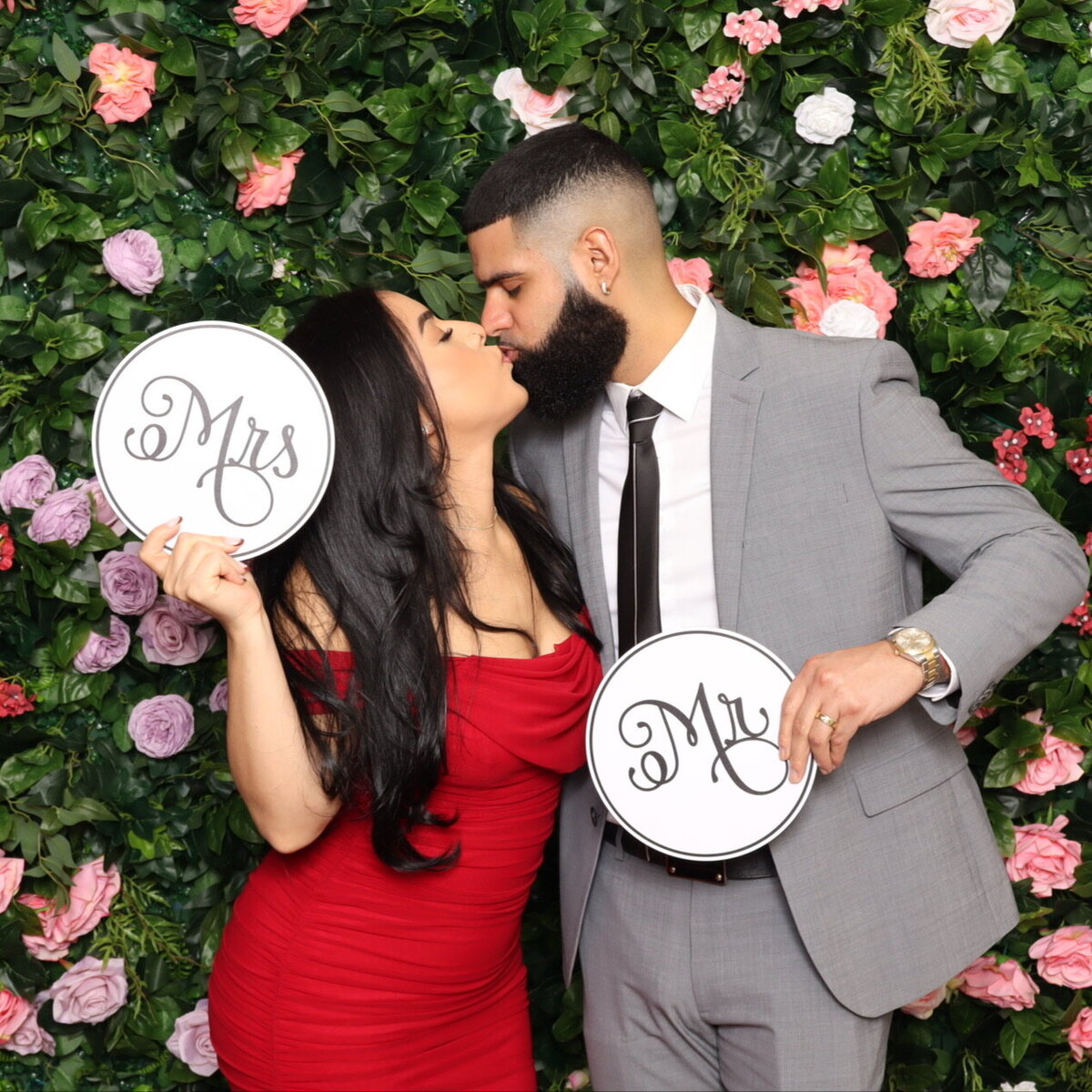 Mr and Mrs Kiss in Front of Flower Wall
