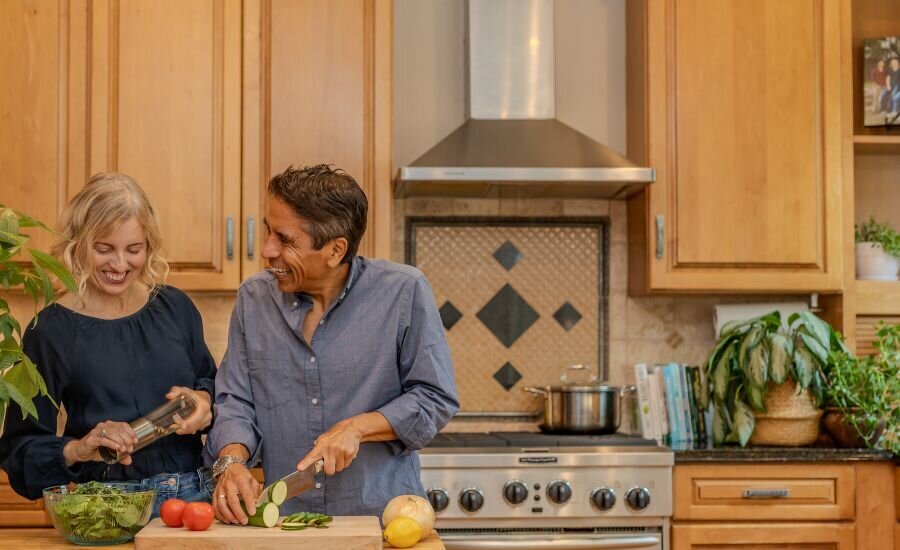 Nayon and Lisa Tomsio  cooking healthy plant-forward meal in kitchen